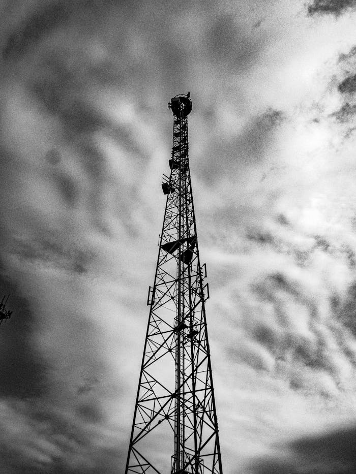Black and white image of a radio mast in Sorocaba, Brazil, under a cloudy sky.